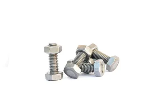 Metal bolts scattered on white surface for hardware project Stock Photos