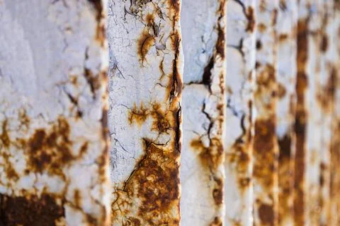 Metal bridge railing with corrosion, rust, deep cracks, and paint flaking Stock Photos