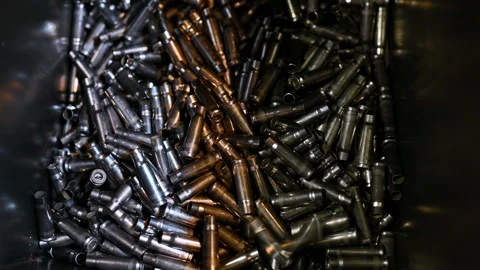 Metal bullet casings fall down into large container at plant Stock Footage 251693637