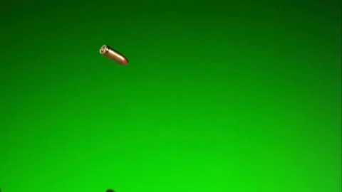 Metal bullets falling down against a bright green screen Stock Footage 327514435
