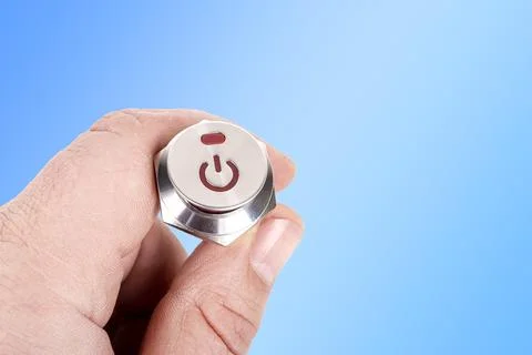 Metal button. background. it has a power symbol painted on it, a human hand i Stockfoto's