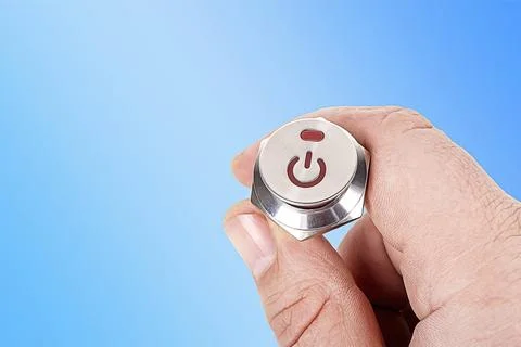 Metal button. background. it has a power symbol painted on it, a human hand i Stockfoto's