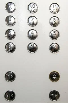 Metal buttons with numbering on the elevator panel. Stock Photos