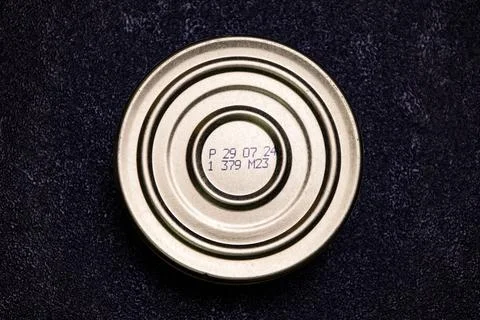 Metal can lid with manufacturing code and date stamped on surface placed on a Stockfoto's