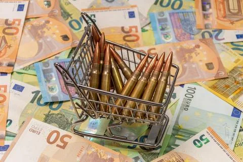 Metal cart with bullets placed on surface of euro banknotes. 写真素材