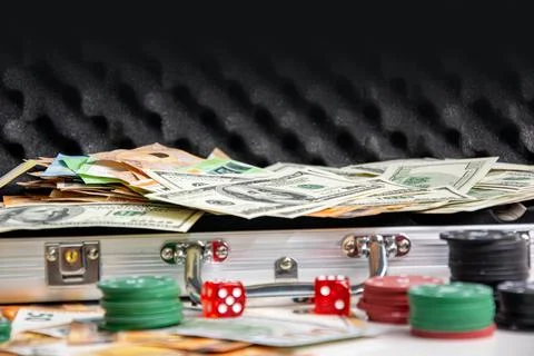 A metal case with a black interior filled with US dollar bills and euro bills Stock Photos