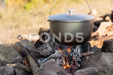 Metal cauldron boiling on a bonfire. Cooking on open fire Stock Photos