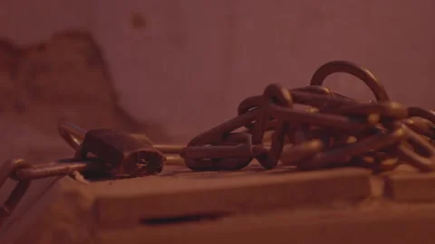 Metal chain and lock with a rusty link rocks. Flickering electric light in Stock Footage 238468353