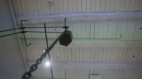 Metal chain extends high with hook supporting wooden bucket Stock Footage 295840087