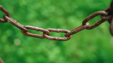 A metal chain is hanging on a background of green grass Stock Footage 340138682