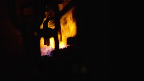 Metal chain links heating inside a blacksmith forge with bright flames and Stock Footage 328994171