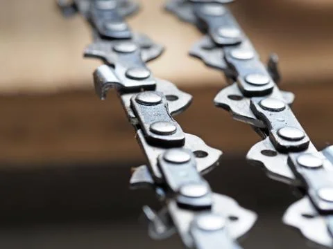 Metal chainsaw chain with sharp teeth close-up with blurred background Stock Photos