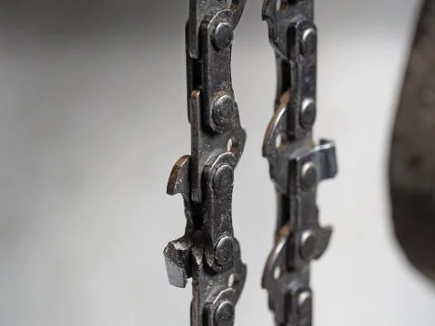 Metal chainsaw chain with sharp teeth close-up with blurred background Stock Photos