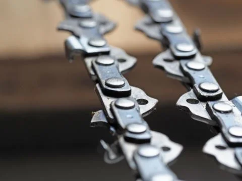 Metal chainsaw chain with sharp teeth close-up with blurred background Stock Photos