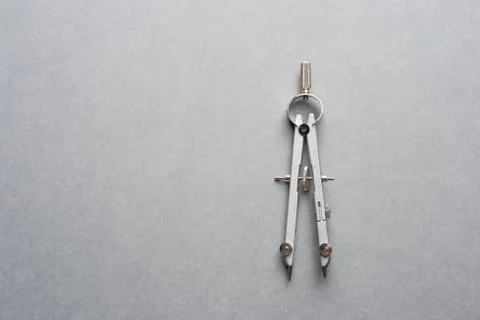 A metal compass on grey background Stock Photos