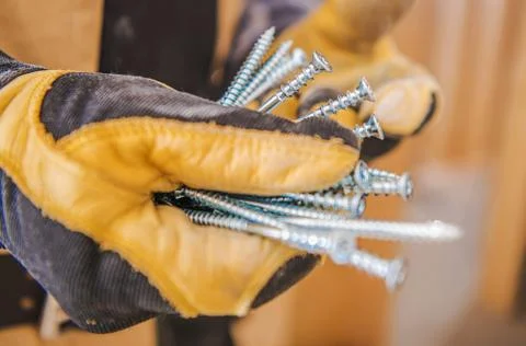 Metal Construction Screws in Workers Hands Closeup Photo. Industrial Theme. 스톡 사진