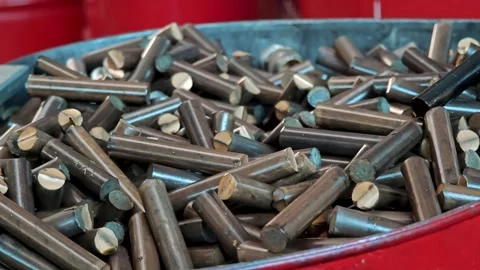 Metal container filled with small brass cylindrical blanks. Raw material for Video stock 329289032