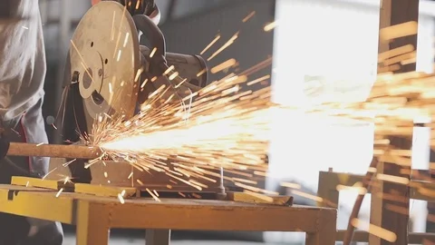 Metal cutting saw cuts a thin square tube, orange sparks from metal cutting saw. Stock Footage 93783005