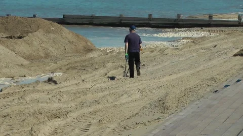 Metal detecting detector beach sand sea breakwater man Stock Footage 49461304