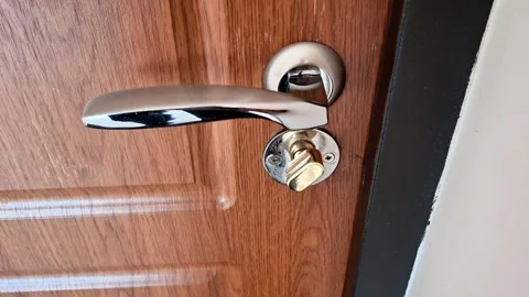 Metal Door Handle with Key in Lock on Wooden Door Frame Stock Footage 331375683
