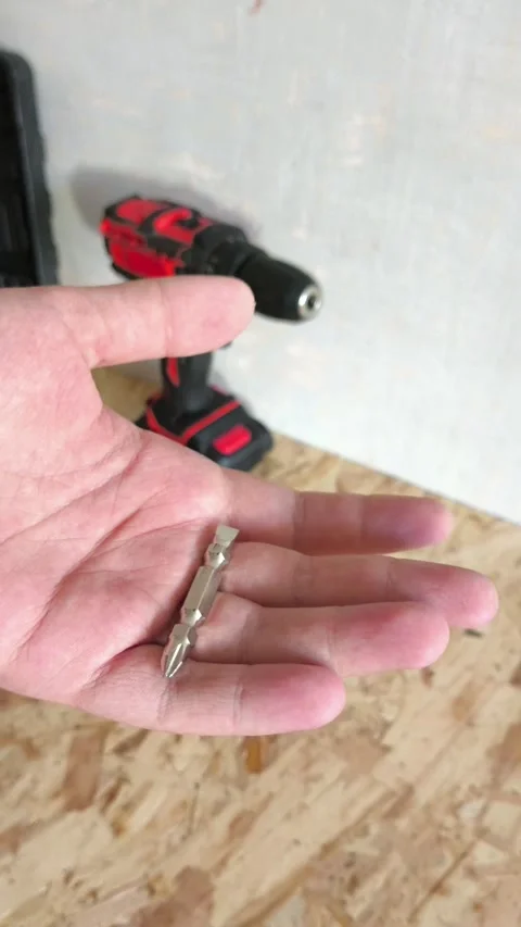 Metal drill bit for screwdriver, Power drill in hand close-up. Tool attachments. Video stock 322894230
