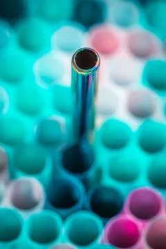 Metal drinking straw between othe ordinary plastich ones. Ecology zero waste Stock Photos
