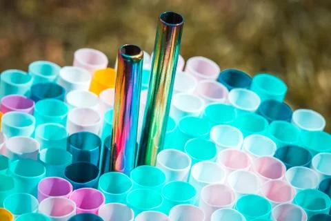 Metal drinking straw between othe ordinary plastich ones. Ecology zero waste Stock Photos