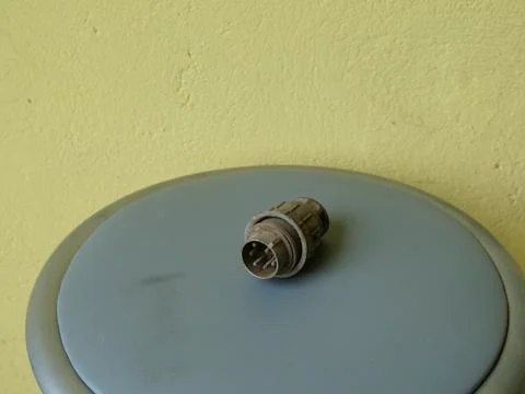 Metal electrical connector lying on stool surface, macro view of technical de Stock Photos