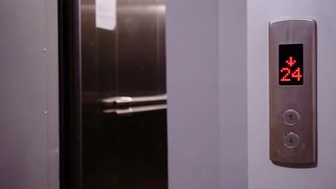 Metal elevator doors open, with the elevator call button in the foreground Stock Footage 217406522