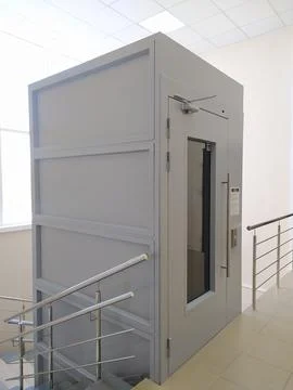 Metal elevator for transporting people with disabilities in the interior Stockfoto's
