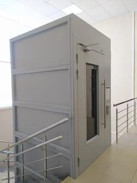 Metal elevator for transporting people with disabilities in interior of building Stock Photos