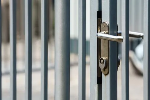 Metal fence with lock that opens with triangular key Stock Photos