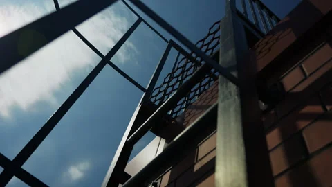 Metal fire escape structure on brick building against blue sky Stock Footage 346549736