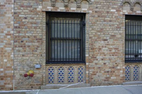 Metal fire hydrant valve on brick wall of building, firefighting equipment Stock Photos