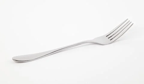 Metal fork lying on a white background. Front view. Stock Photos