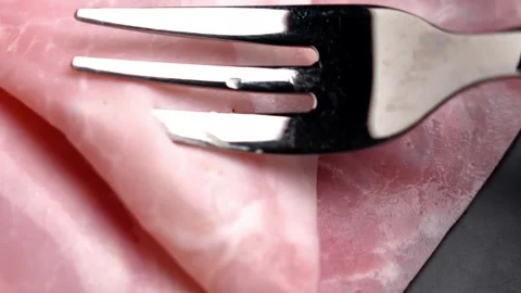 Metal fork piercing a thin slice of cooked ham. Stock Footage 334055352