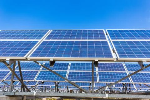 Metal frames with rows of blue solar collectors and sky Stock Photos