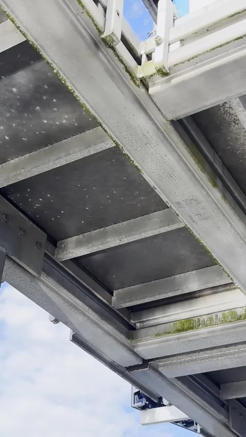 Metal Framework Beneath Waterside Structure With Reflected Light Stock Footage 345095376