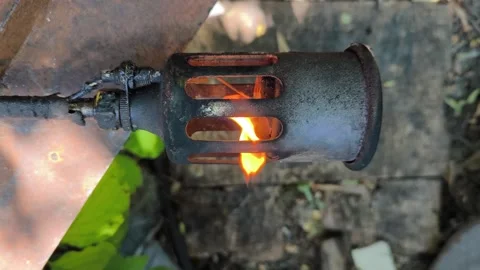 A metal gas burner producing an open flame. Industrial heating equipment op.. Stock Footage 338041895