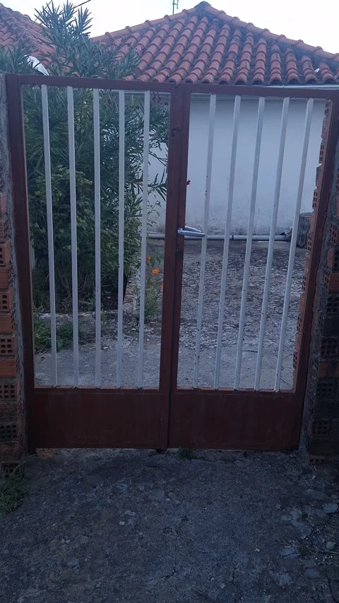 Metal Gate Entrance with Bars – Rustic Courtyard View in 8K Stock Footage 318419487