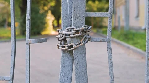 A metal gate is secured with chains, showing a close-up of the lock mechanism. Stock Footage 344667663