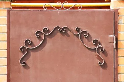 Metal gates with a pattern in the form of curls covered  paint. Stock Photos