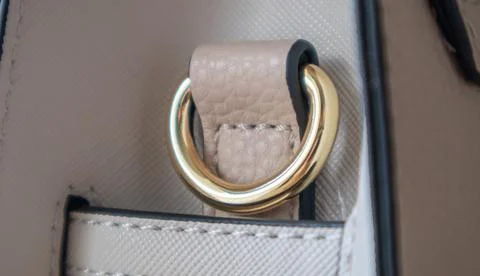 Metal gold loop oval ring attached to a leather bag. Selective focus. Part fo Stock Photos