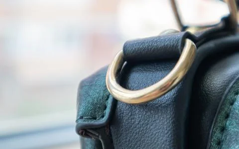 Metal gold loop oval ring attached to a leather bag. Selective focus. Part fo Stock Photos