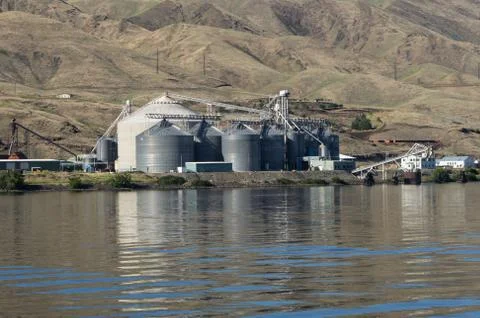 Metal grain elevator storage on river Foto stock