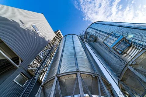 Metal grain elevators on modern factory. Crop storage in factory. Selective f Stock Photos