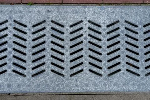 Metal grate of the drain. Stock Photos