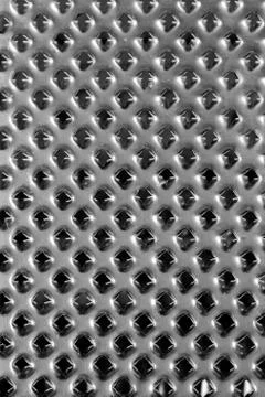 Metal grater, surface with sharp spiky holes, backdrop texture. Gray silver m Stock Photos
