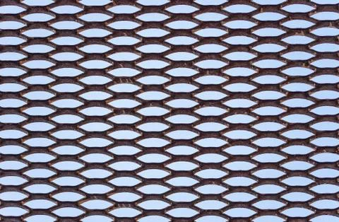 Metal grid with regular pattern on blue background Stock Photos