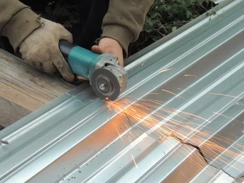 A metal grinder in the hands of a builder Stock Photos